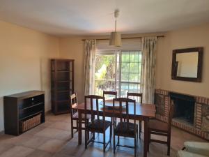 une salle à manger avec une table et des chaises et une cheminée dans l'établissement Chalet el castillo, à La Adrada