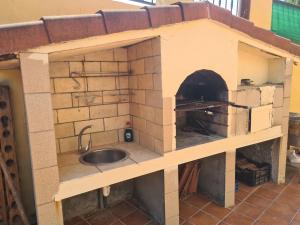 une cuisine avec un évier dans un four en briques dans l'établissement Chalet el castillo, à La Adrada