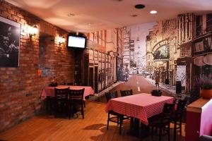 a restaurant with two tables and a brick wall at Hotel Orlik in Płońsk