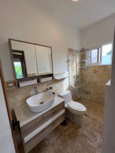 a bathroom with a sink and a toilet at Luxury Private Villa At Metro Pool Jacuzzi Wifi Sleeps 10 in Juan Dolio