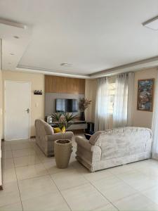 a living room with two couches and a tv at Linda casa pertinho de Tiradentes in São João del Rei