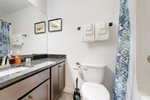 Un baño con inodoro, lavabo y ducha. en Sea Renity, en Rockaway Beach