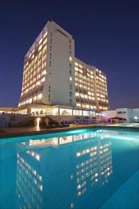 a building with a swimming pool in front of a building at Anezi Tower Hotel in Agadir