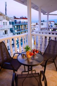 a table with two glasses of wine on a balcony at Hotel Ilion in Paralia Katerinis