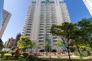 un grand bâtiment blanc avec des arbres devant dans l'établissement Flat Moderno p/ Negócios em Asa Norte BHY0614, à Brasilia