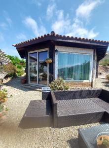 Una pequeña casa con una gran ventana que da a un patio de grava. en Lluvia's Place, en Ensenada