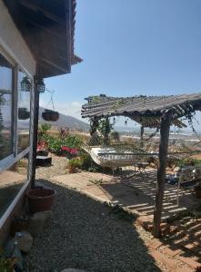Un patio con una mesa y un banco y un edificio. en Lluvia's Place, en Ensenada
