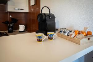 due tazze di caffè sedute su un bancone in cucina di Suite Capitana Harbor-Self Checkin-Terrace-Netflix a Santa Luria Altre 29 foto