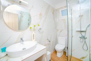 a bathroom with a sink and a toilet and a mirror at Hotel Ilion in Paralia Katerinis