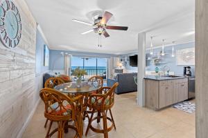 a dining room and kitchen with a table and chairs at Sunset Terrace 109 in Bradenton Beach