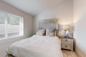 a white bedroom with a bed and a window at Harrington Hideaway in Coupeville +9 photos