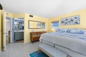 a bedroom with a bed and a bathroom with a sink at Sunset Terrace 109 in Bradenton Beach +28 photos