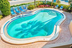 a swimming pool with chairs and a swimming pool at Sunset Terrace 109 in Bradenton Beach