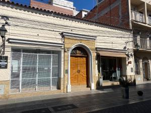 a brick building with a wooden door on a street at Casa en centro salteño in Salta