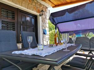 ein Tisch mit Weingläsern auf einer Terrasse in der Unterkunft Apartman Rahela in Selce