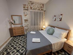 a bedroom with a large bed with towels on it at Stone-built Villa Nesseris 80 m2 in Preveza