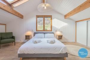 a bedroom with a large bed and a green chair at LEscapade du Col Cozy 2-Bedroom Apartment in Bluffy