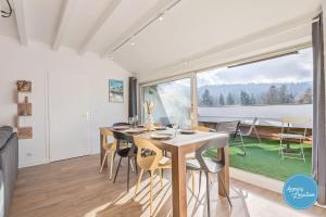 a dining room with a table and chairs and a large window at LEscapade du Col Cozy 2-Bedroom Apartment in Bluffy
