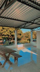 a wooden picnic table sitting under a metal roof at Rancho do allan in Três Marias