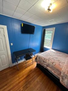 a bedroom with a bed and a desk with a television at Fidelia Fuchsite Room, Queen Bed minutes from Newark Liberty international Airport and Newark Penn Station in Irvington