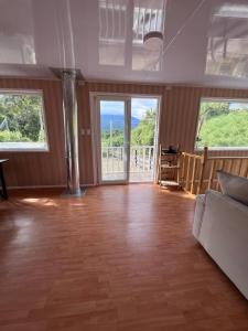 a living room with wood floors and windows and a couch at Cabañas ROMA, entre volcanes in Puerto Varas +11 photos