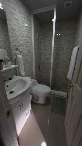 a white bathroom with a sink and a toilet at Cabañas ROMA, entre volcanes in Puerto Varas