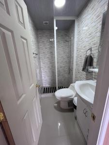 a bathroom with a white toilet and a sink at Cabañas ROMA, entre volcanes in Puerto Varas