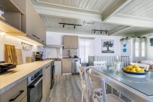 a kitchen with a large island with a bowl of fruit on the counter at Amorama Suites - Authentic Village Stay in Glossa in Glossa