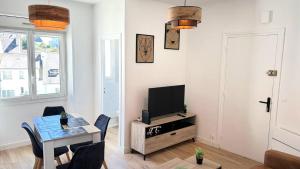 a living room with a table and a television at La Reconquête des remparts in Hennebont
