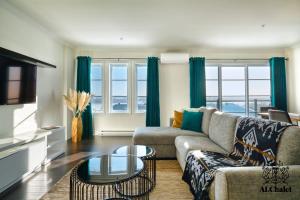 a living room with a couch and a table at Le Chic Condo - chute Montmorency in Boischâtel