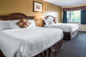 a hotel room with two beds and a window at TiltonLodge Inn & Suites in Tilton +29 photos