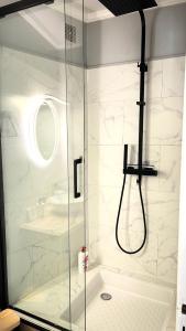 a shower with a glass door in a bathroom at La Reconquête des remparts in Hennebont +14 photos
