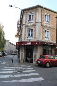 ein rotes Auto, das vor einem Gebäude parkt in der Unterkunft Le Kleber in Montreuil