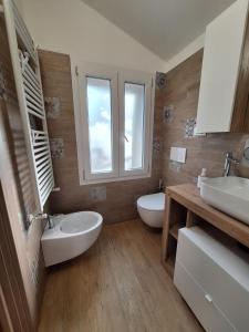 a bathroom with two sinks and two toilets at Casa Martin 2 in Tolè +8 photos