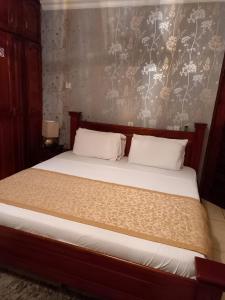 a bedroom with a large bed with white pillows at Benconi Lodge in Accra
