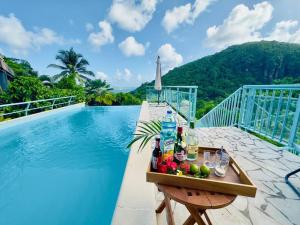 a tray of drinks on a table next to a swimming pool at Maison T3 - Vue sur la Baie du Marin, Piscine in Le Marin +18 photos