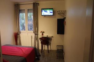 a bedroom with a bed and a table and a television at Le Kleber in Montreuil