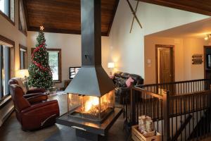 a living room with a christmas tree and a fireplace at Au Grand Merisier : Chalet alpin in Petite-Rivière-Saint-François