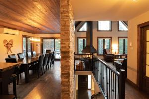 a dining room and living room with a table and chairs at Au Grand Merisier : Chalet alpin in Petite-Rivière-Saint-François