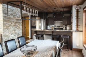 a kitchen and dining room with a table and chairs at Au Grand Merisier : Chalet alpin in Petite-Rivière-Saint-François
