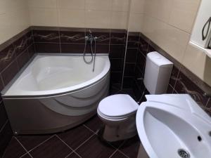 a bathroom with a tub and a toilet and a sink at Historia Hostel in Skopje