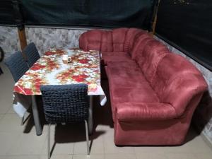 a red couch sitting next to a table and a chair at Historia Hostel in Skopje
