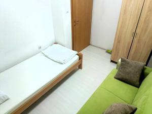 a small room with a bed and a green couch at Historia Hostel in Skopje