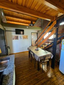 Un comedor con una mesa y una escalera. en Deseo de Montaña, en Maipú 8 fotos más