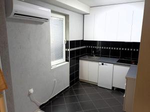 a small kitchen with white cabinets and a window at Historia Hostel in Skopje