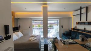 Un dormitorio con una cama y una sala de estar con un sofá. en Larisa Absolute Suites, Sky View Smart Home, en Larisa