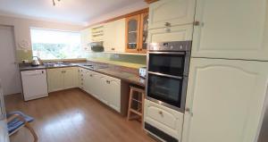 a kitchen with white cabinets and a large window at Willow Cottage 3 bed, cosy stopover, dogs welcome in Thornton-le-Beans