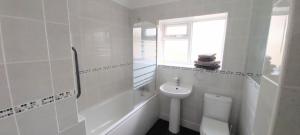 a white bathroom with a toilet and a sink at Willow Cottage 3 bed, cosy stopover, dogs welcome in Thornton-le-Beans +12 photos