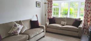 un salon avec deux canapés et une fenêtre dans l'établissement Willow Cottage 3 bed, cosy stopover, dogs welcome, à Thornton-le-Beans 13 autres photos