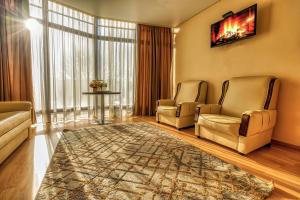 a living room with two chairs and a rug at SV Hotel, Restaurant & Airport Parking in Todoreshty
